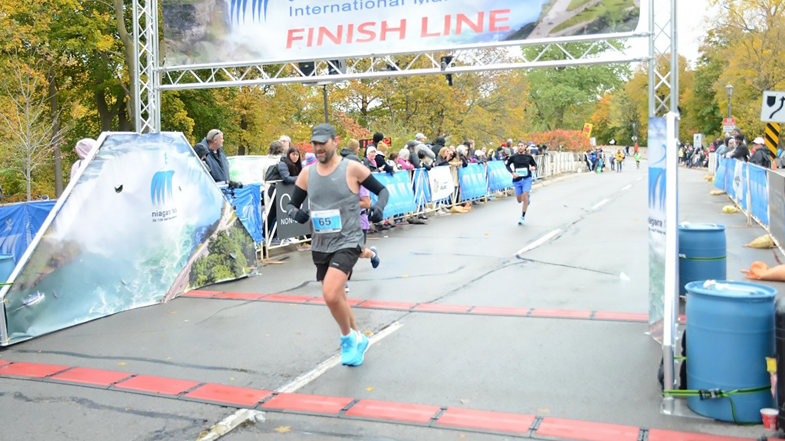 man runs through finish line of a race