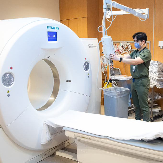 William Chow adjusting CT scan machine