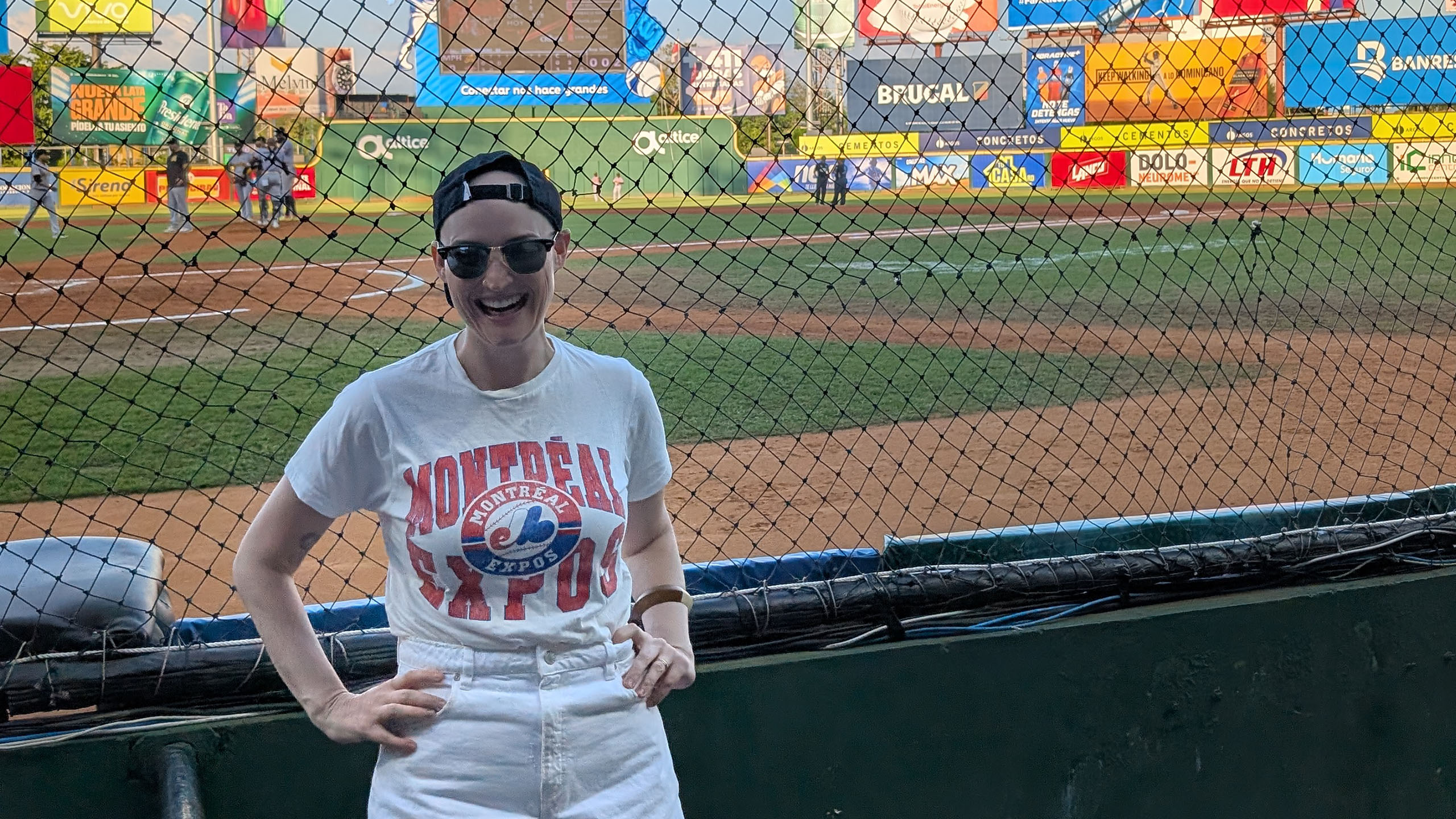 woman stands beside baseball diamond