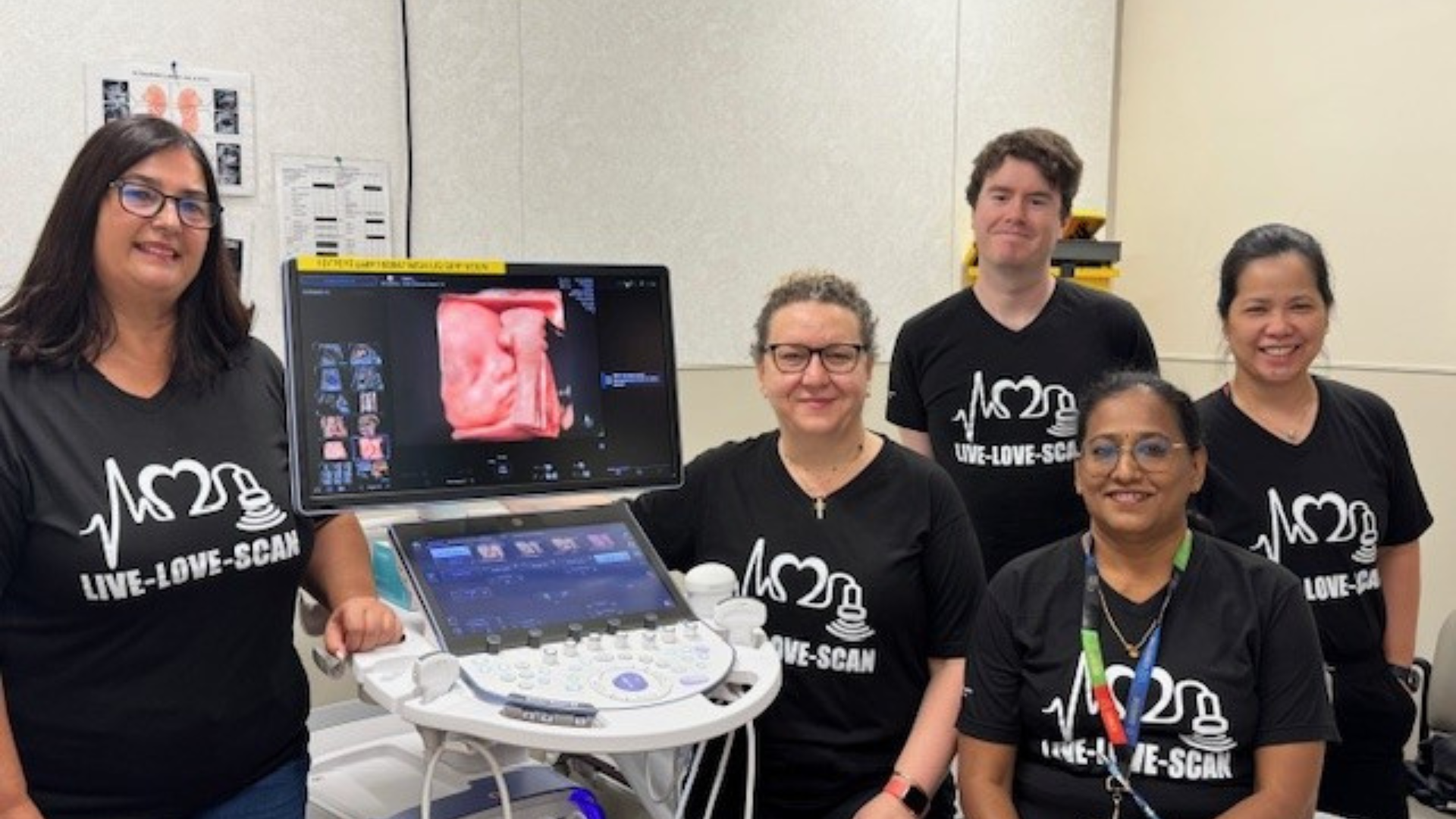 A group of people standing around an ultrasound machine