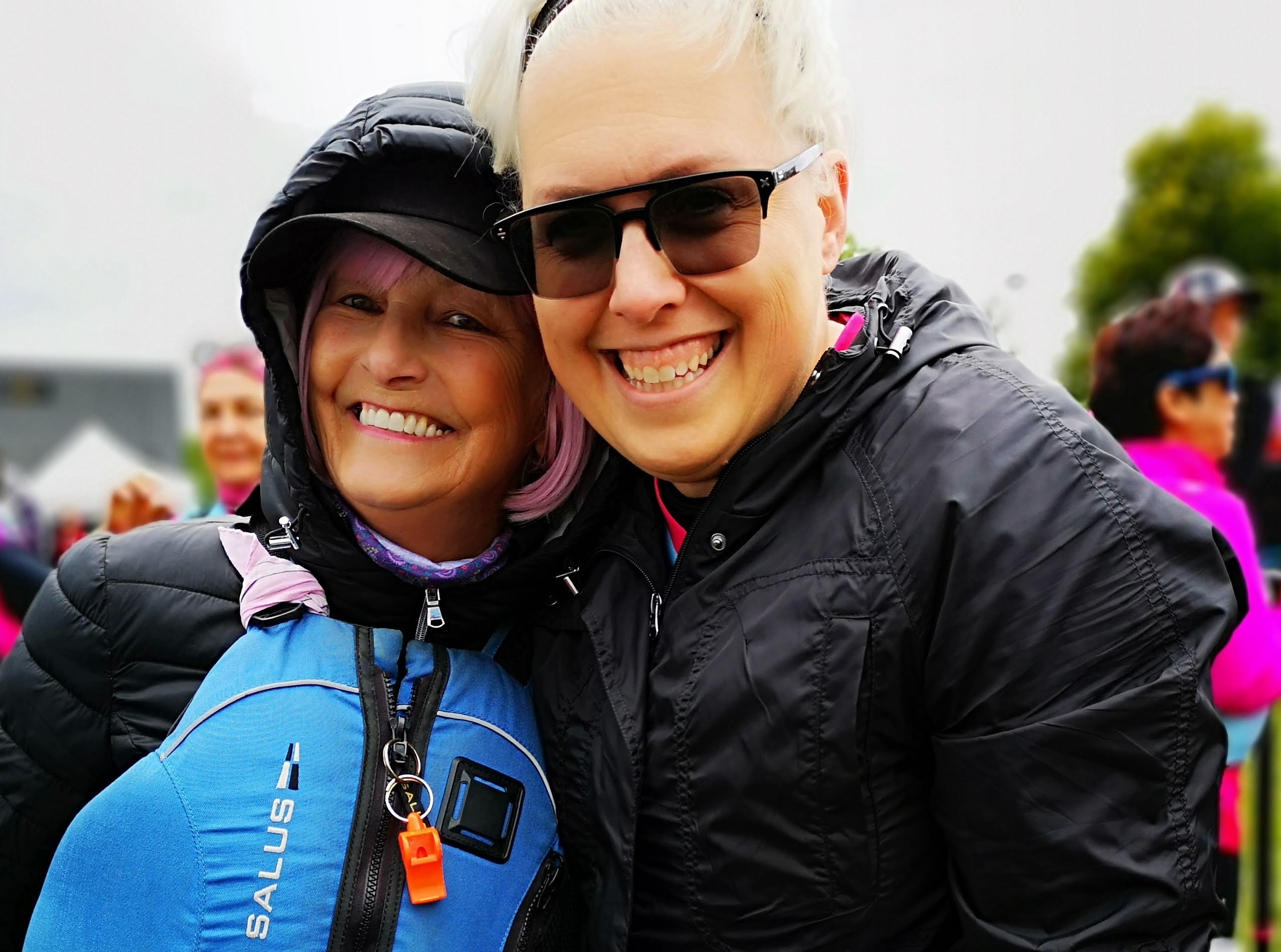 two women outside, one wearing a life jacket