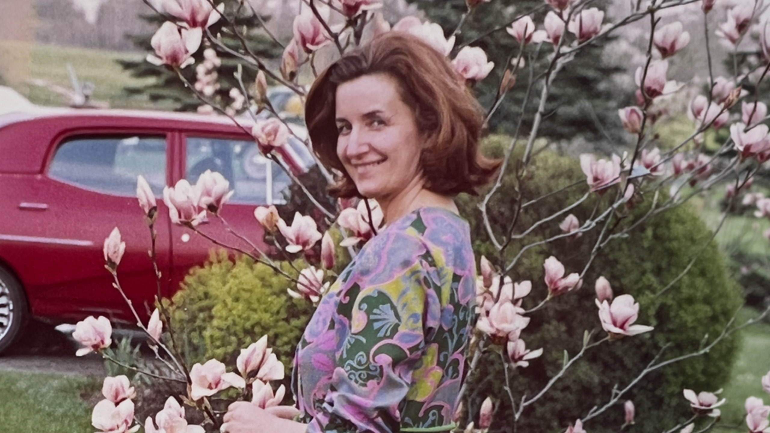 woman stands in front of magnolia tree