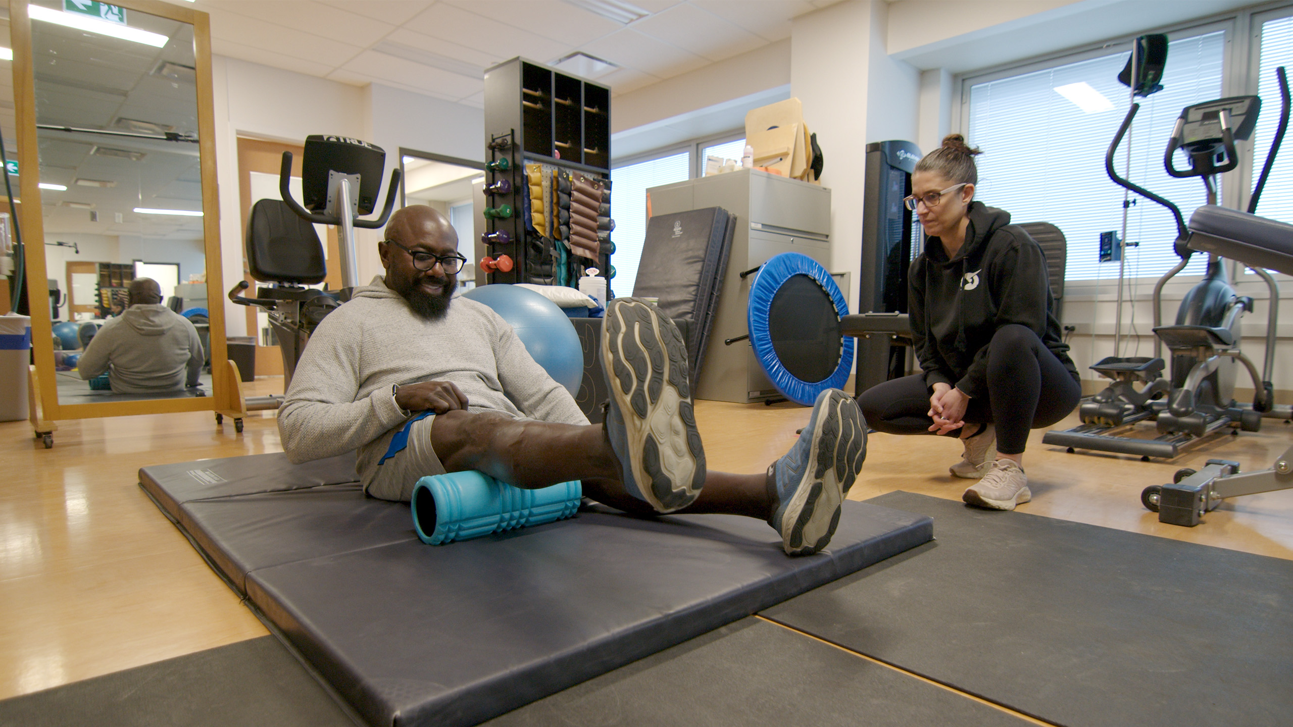 man working out in gym with companion