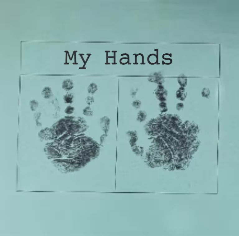 Two dark grey handprints on a pale blue piece of paper with the words My Hands printed in black above