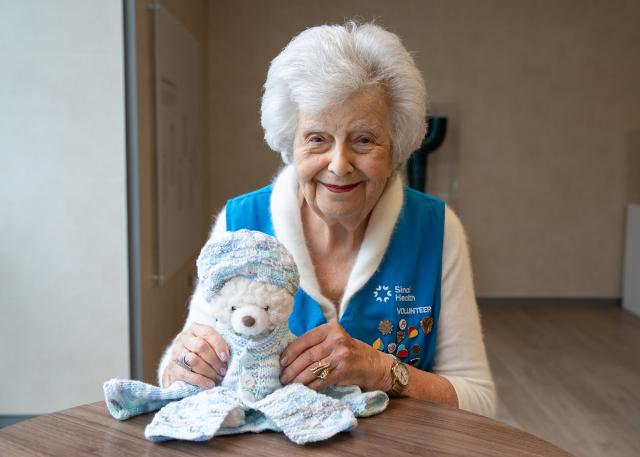 Photo of volunteer holding a teddy bear