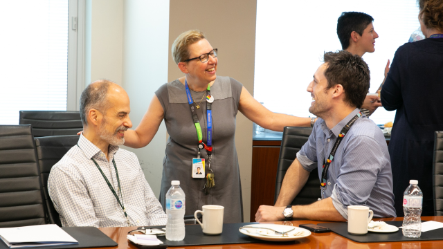 Dr. Maureen Shandling speaking with colleagues in a boardroom.