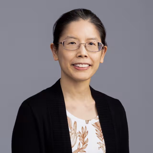 Dr. Vivian Huang wearing glasses and a black cardigan.