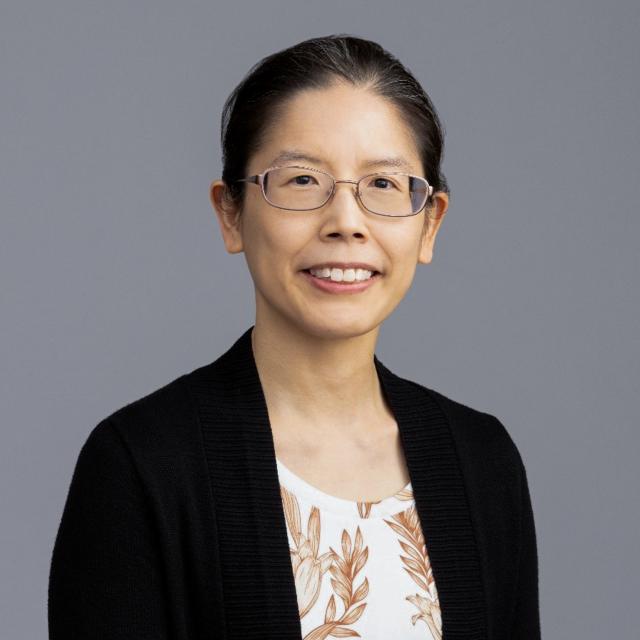 Dr. Vivian Huang wearing glasses and a black cardigan.
