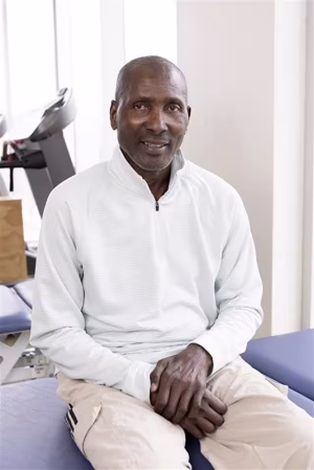 Mr. Solomon sitting in a white sweater.