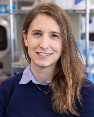 Dr. Diane Haakonsen smiling in a dark blue shirt with light blue collar.