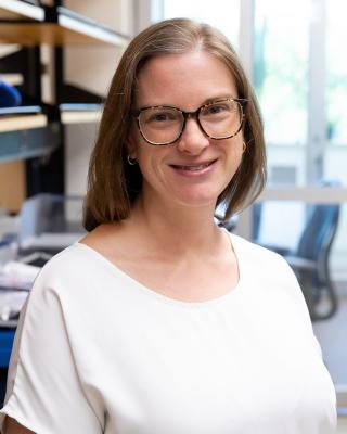 Dr. Katherine Stewart smiling in a cream-coloured shirt. 
