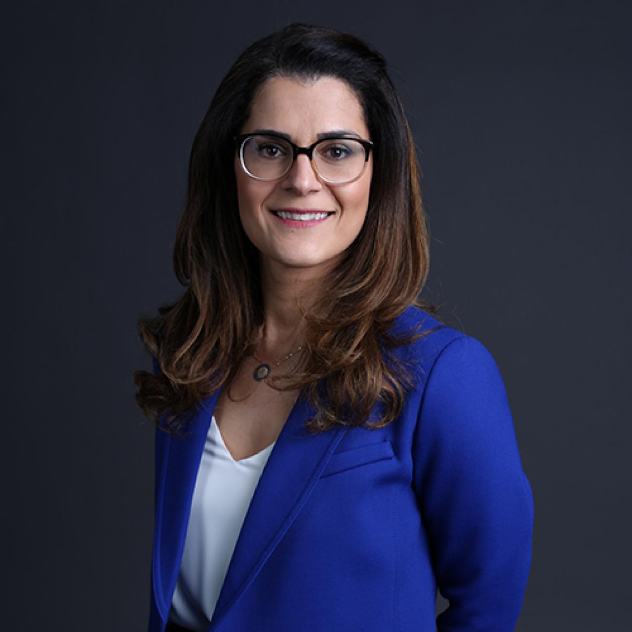 A woman standing facing the camera and smiling