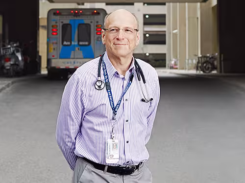 Man standing outside with an ambulance in the background