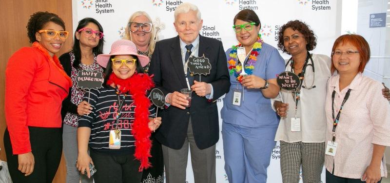 A group of people pose with props from a photo booth.