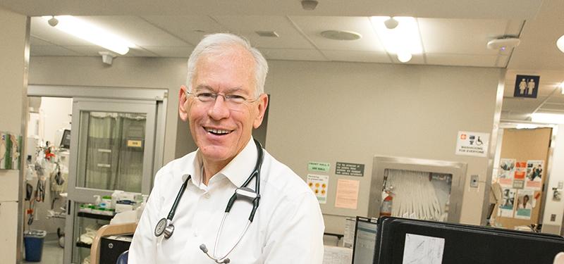 A head shot of a man wearing a stethoscope in a clinic