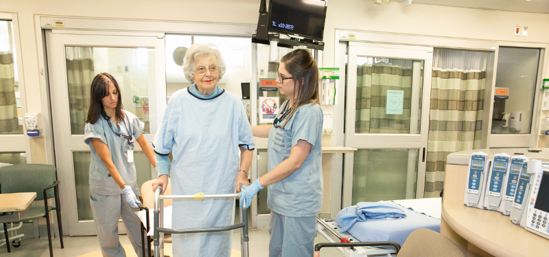 Older adult walks with assistive device