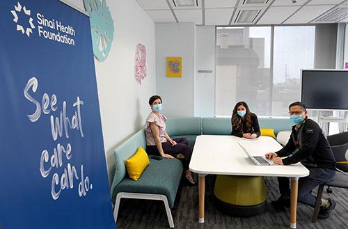 Three Sinai Health Foundation staff members work in their office