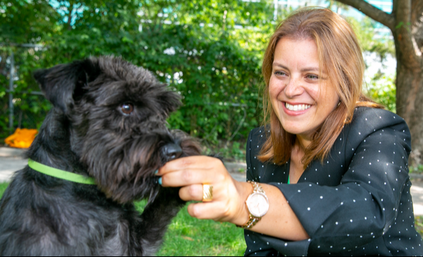 Dr. Caroline Kramer with her black miniature Schnauzer in the park.