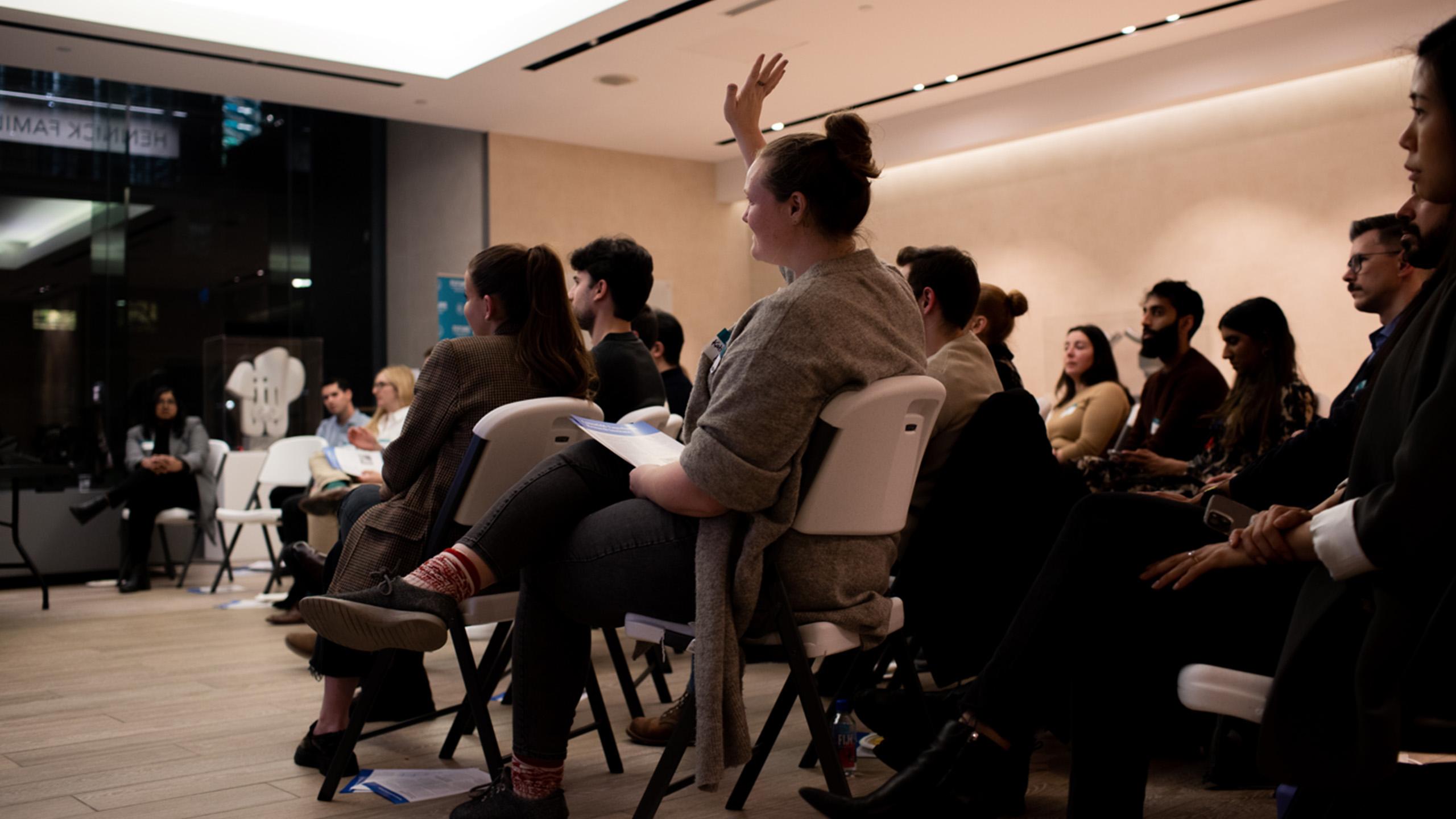Audience with one person raising their hand