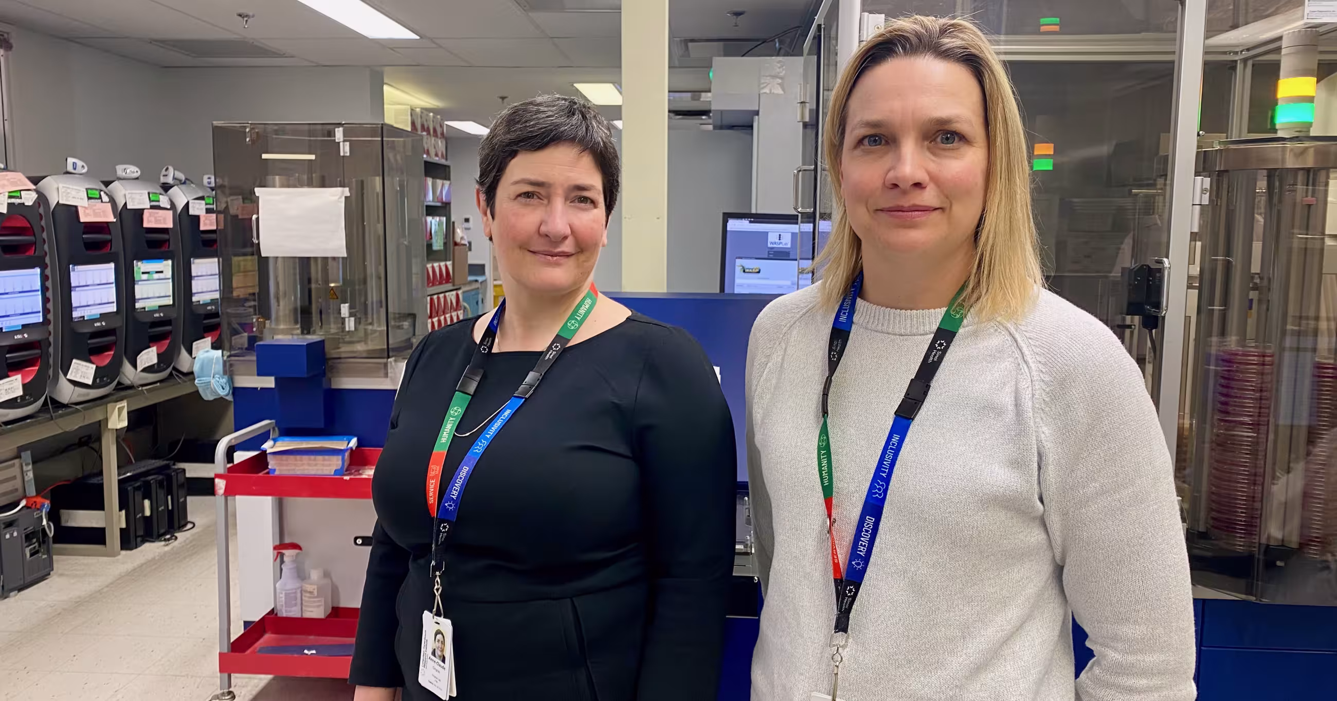 A phone of Dr. Anne-Claude Gingras beside Dr. Jennie Johnstone in the lab. 