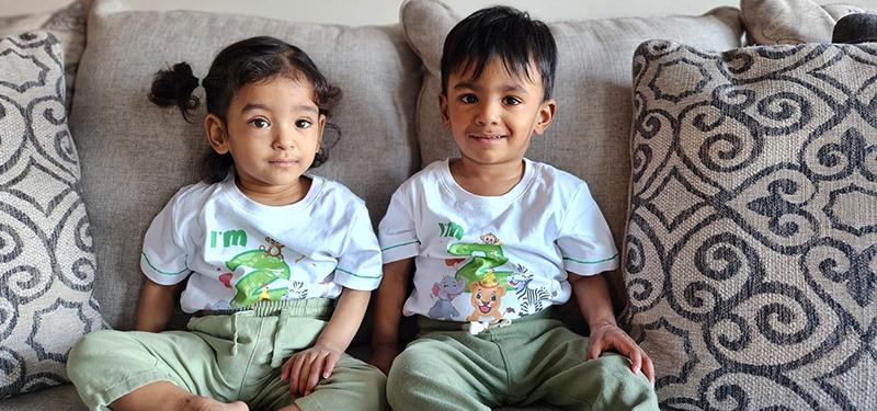 A photo of the world's most premature twins setting beside each other on a couch.