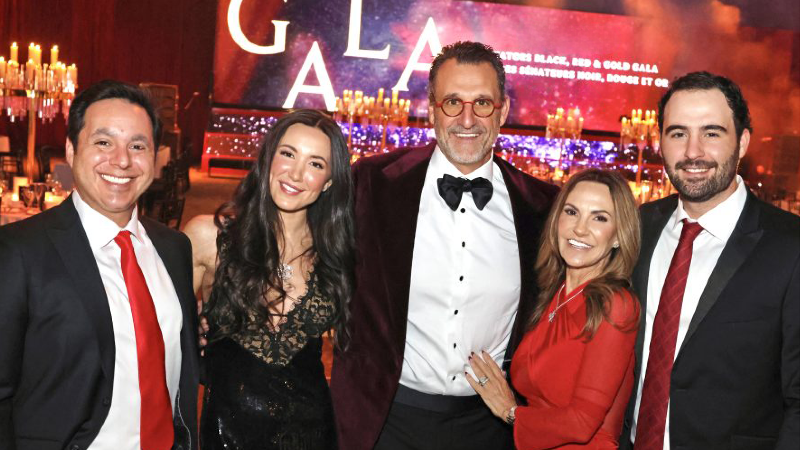 family of five stands smiling