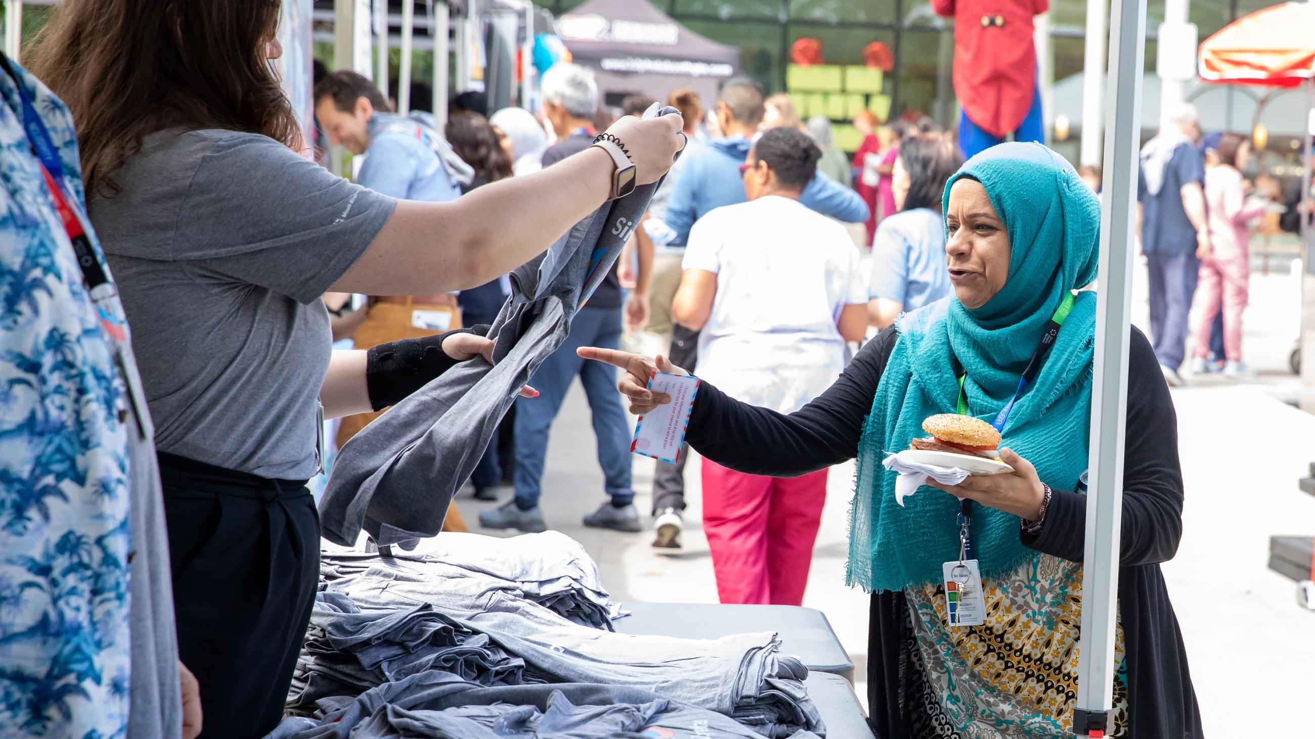 A hospital worker receiving a t-shirt giveaway at the barbeque.