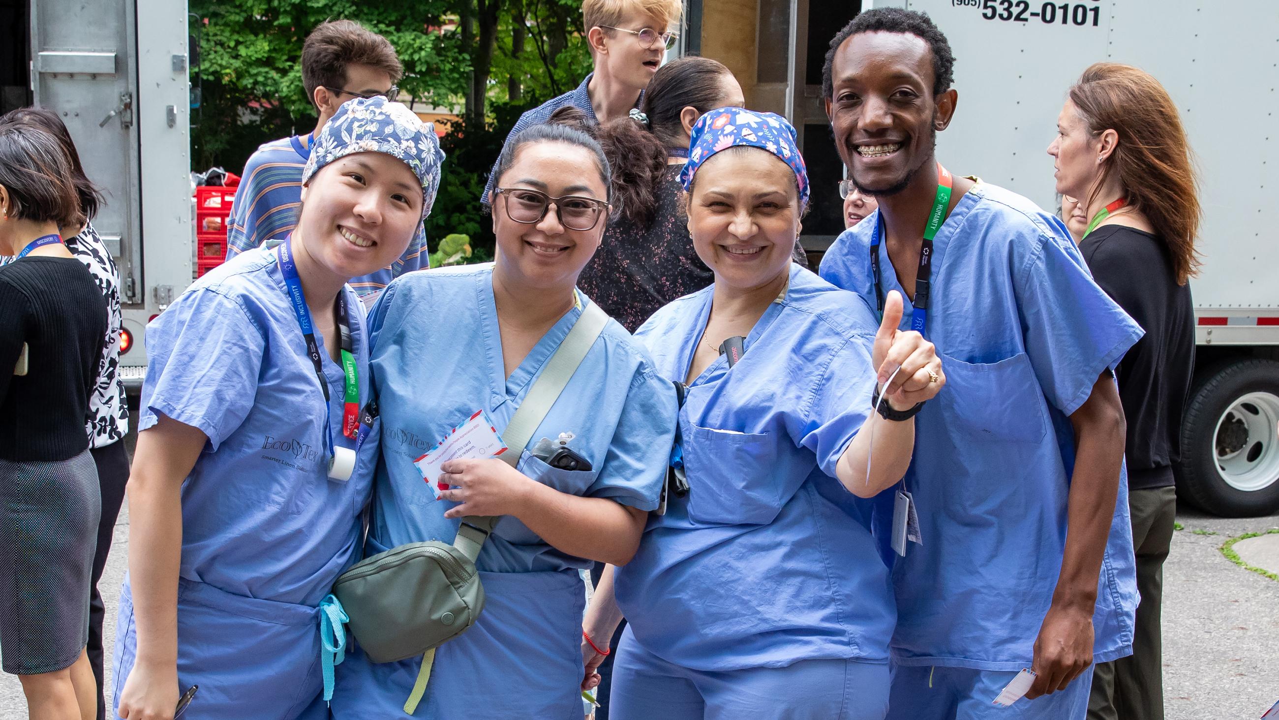 A group of hospital workers smiling together at the barbeque.