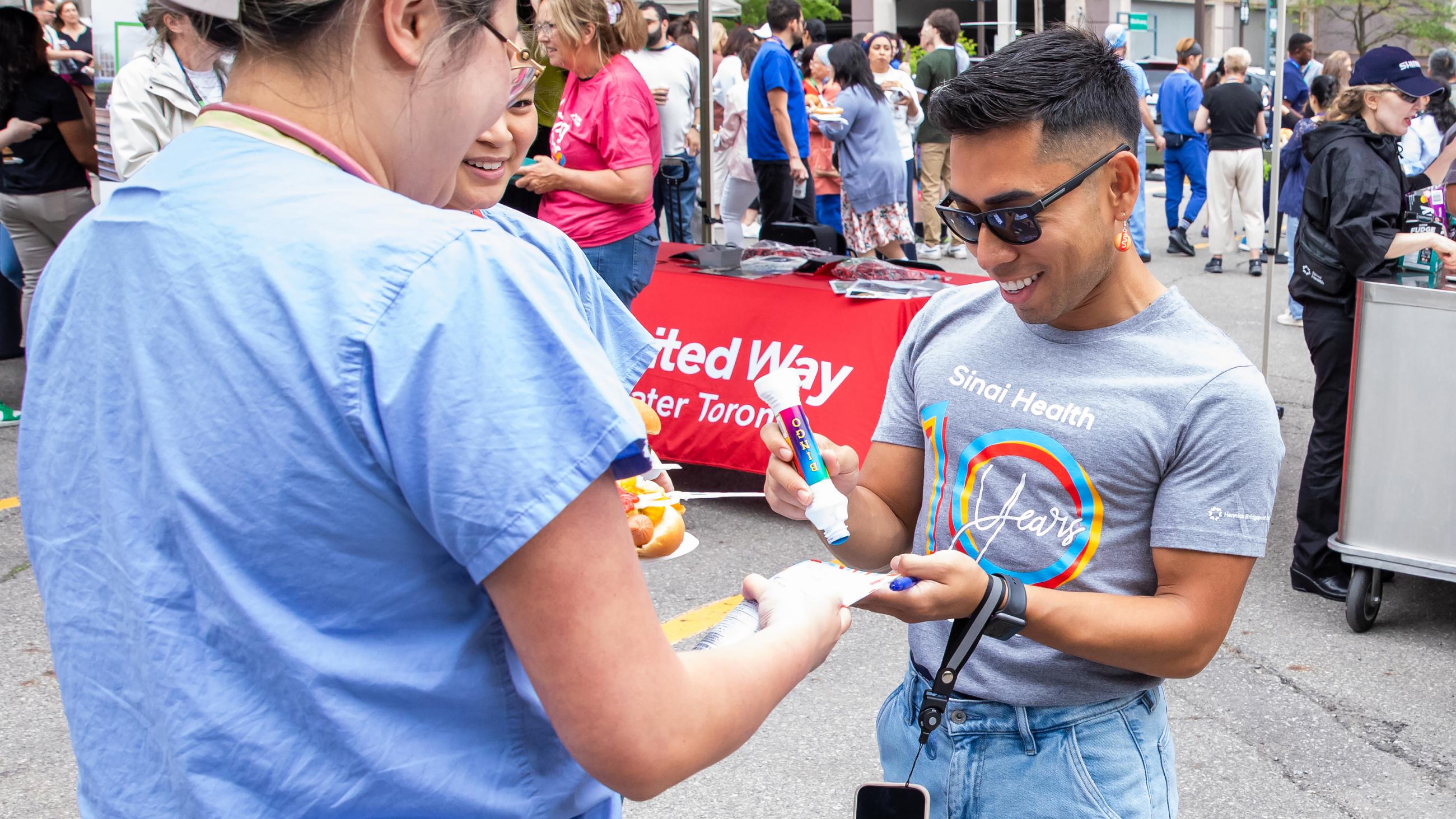 A hospital worker stamping an attendee’s voucher at the barbeque. 