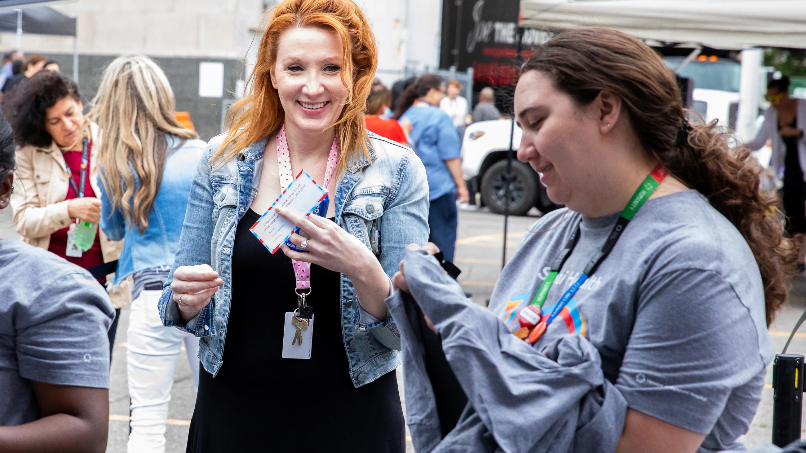 A hospital worker receiving a t-shirt giveaway at the barbeque. 