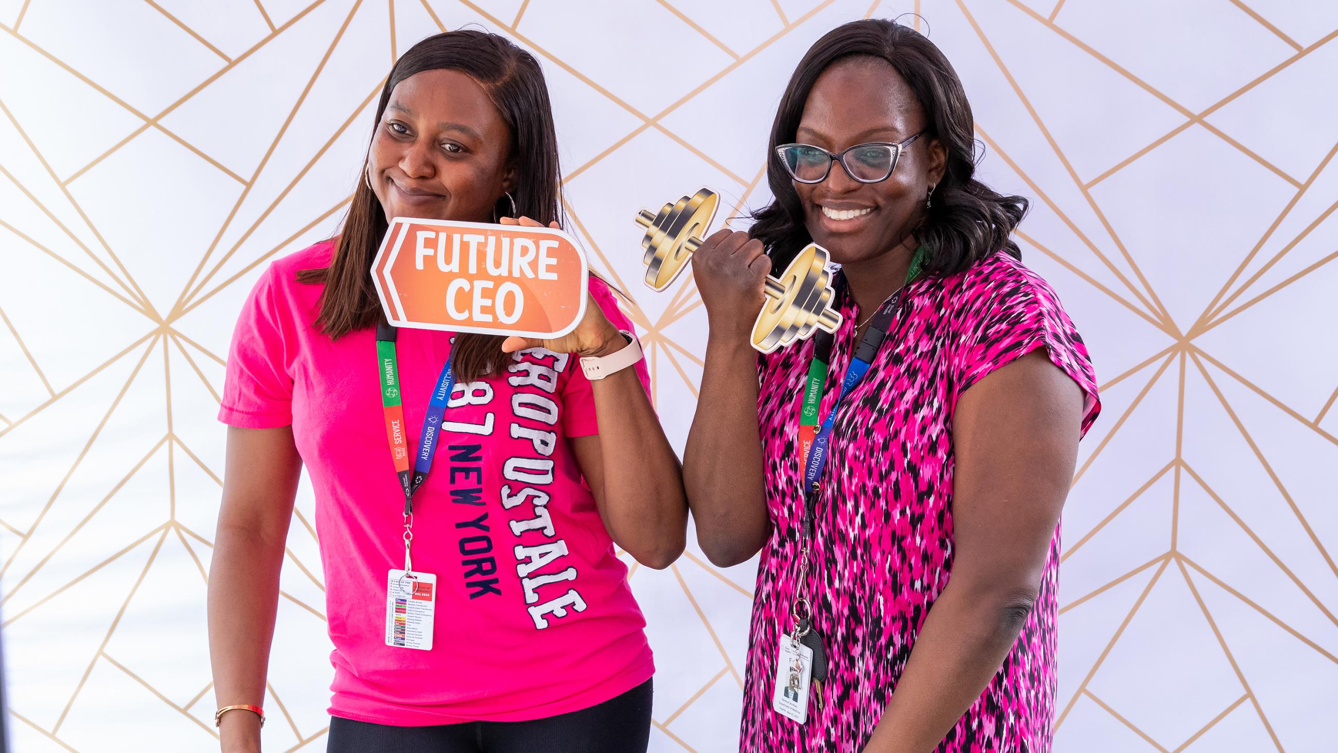 Two colleagues posing together with photo props at the photo booth.