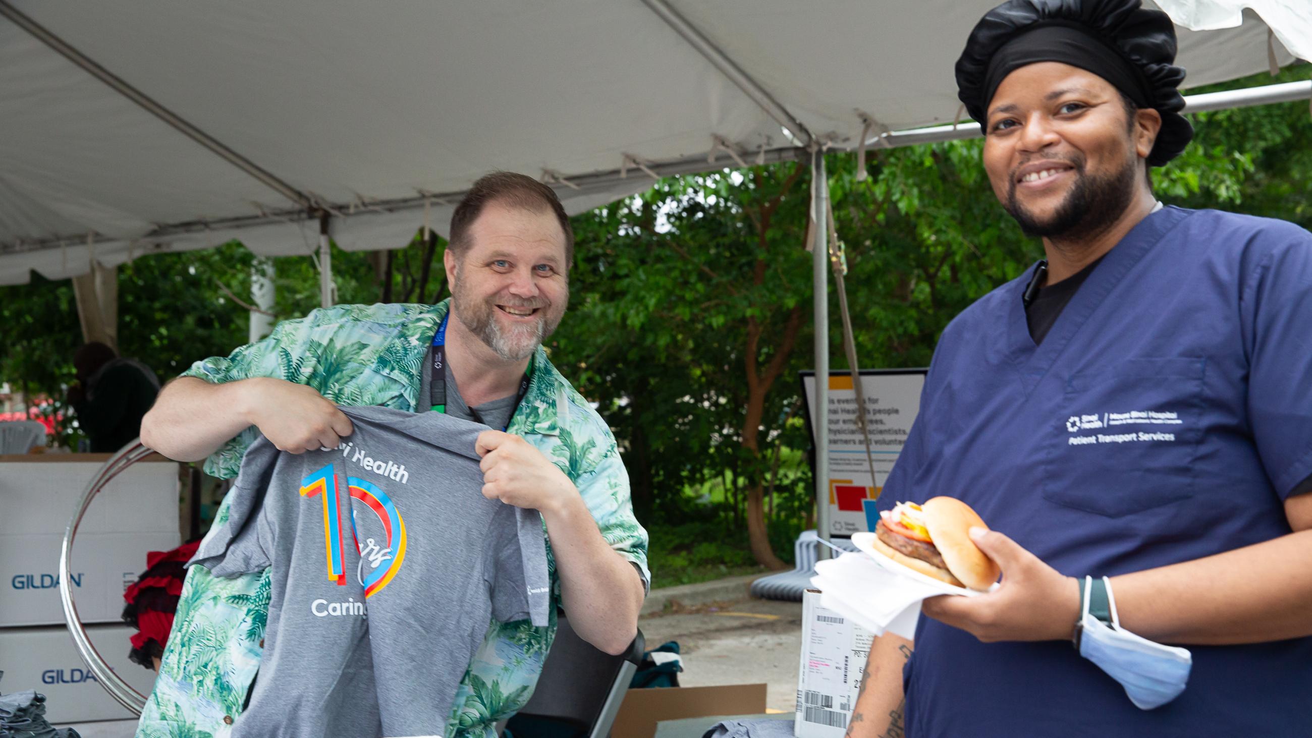A hospital worker receiving a t-shirt giveaway at the barbeque. 