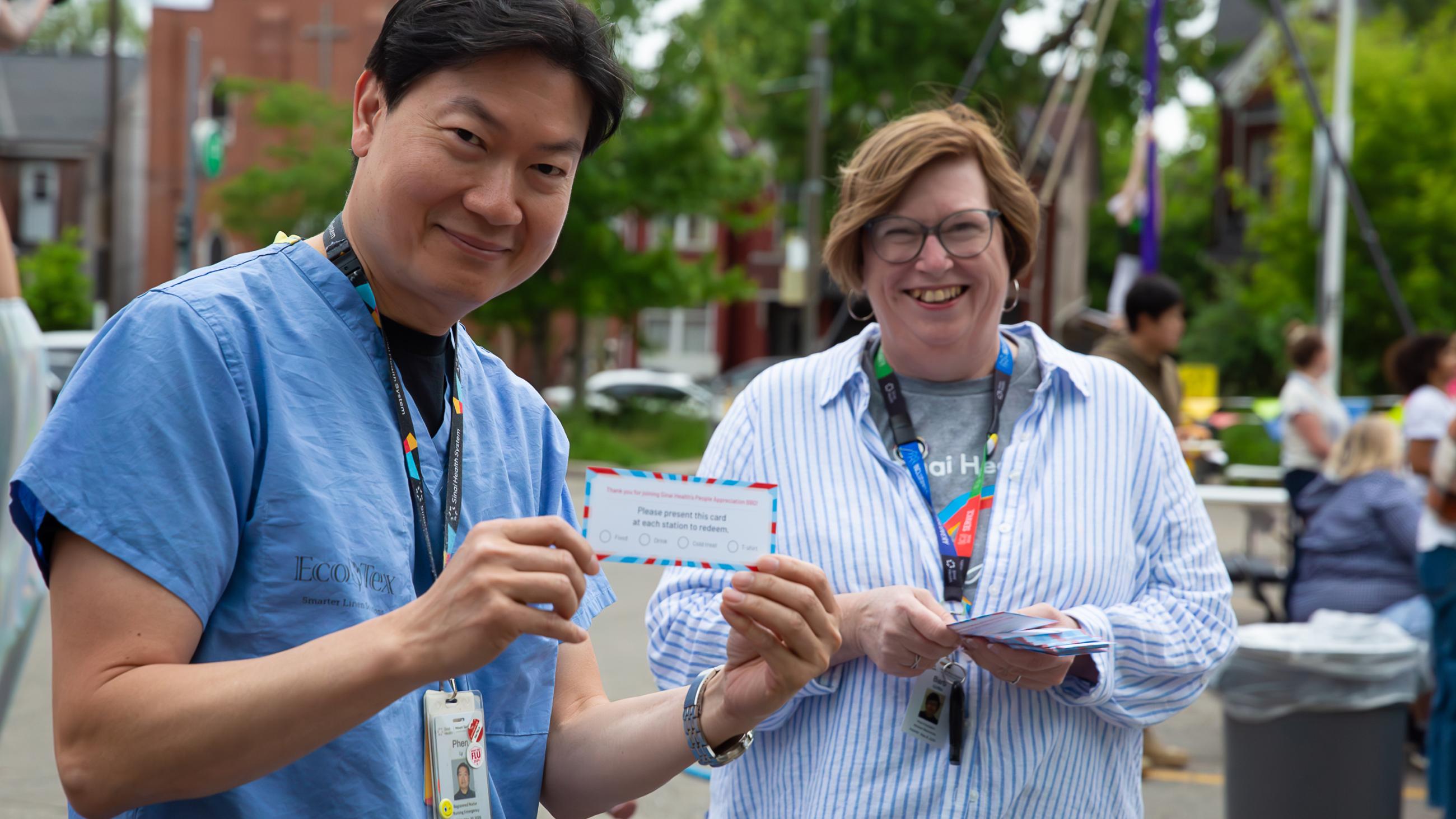 A hospital worker holding up a voucher at the barbeque. 