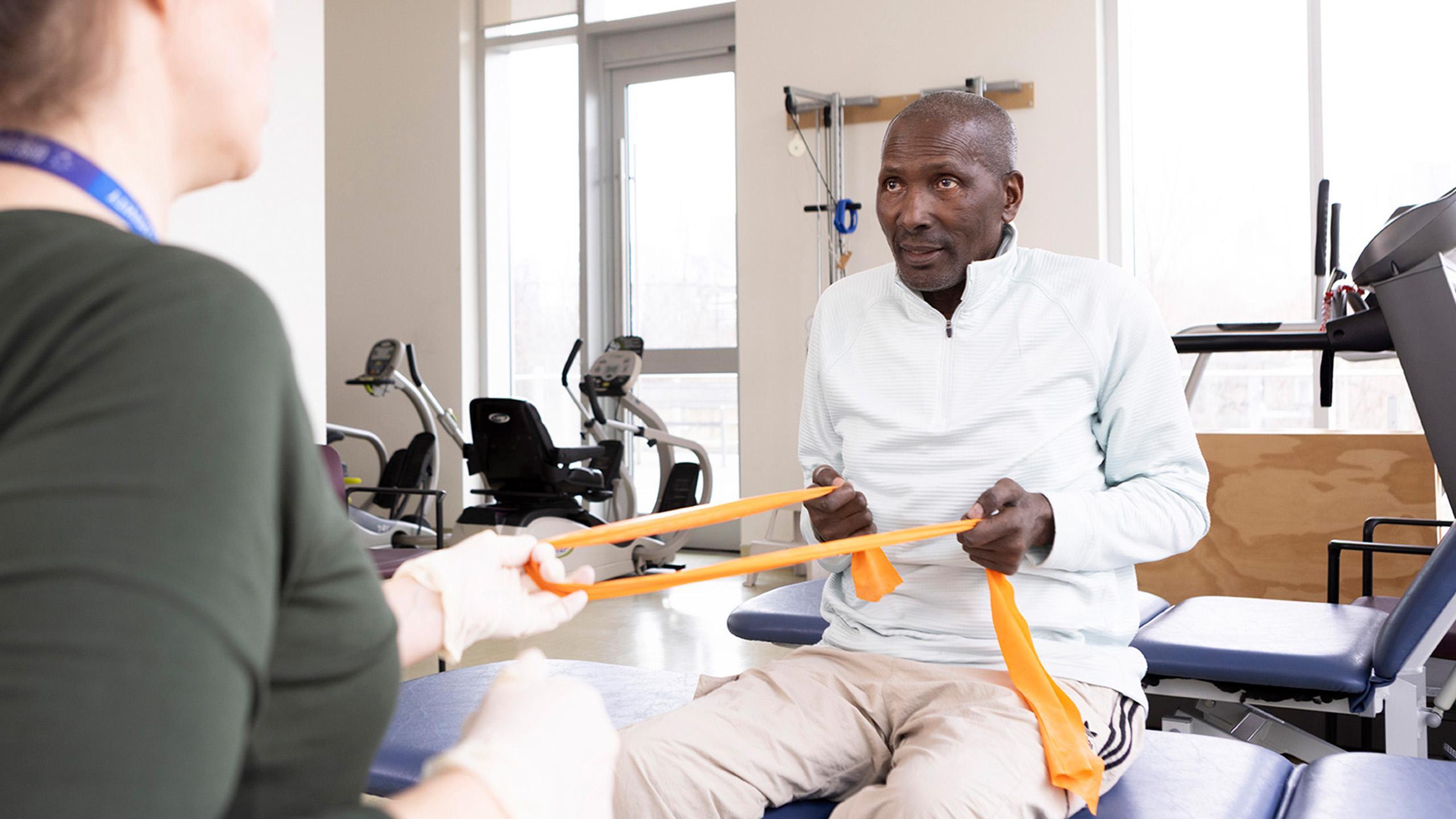 Mr. Solomon using yellow bands during rehab session.