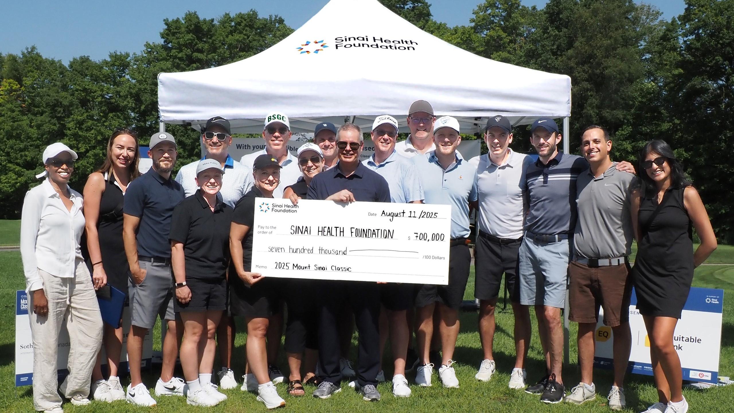 group stands outside holding presentation cheque