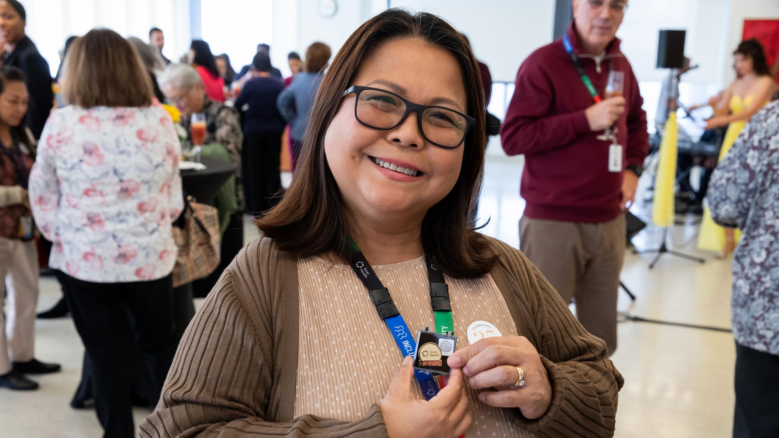 Service milestone recipient smiling while proudly holding up their 35-year service pin.