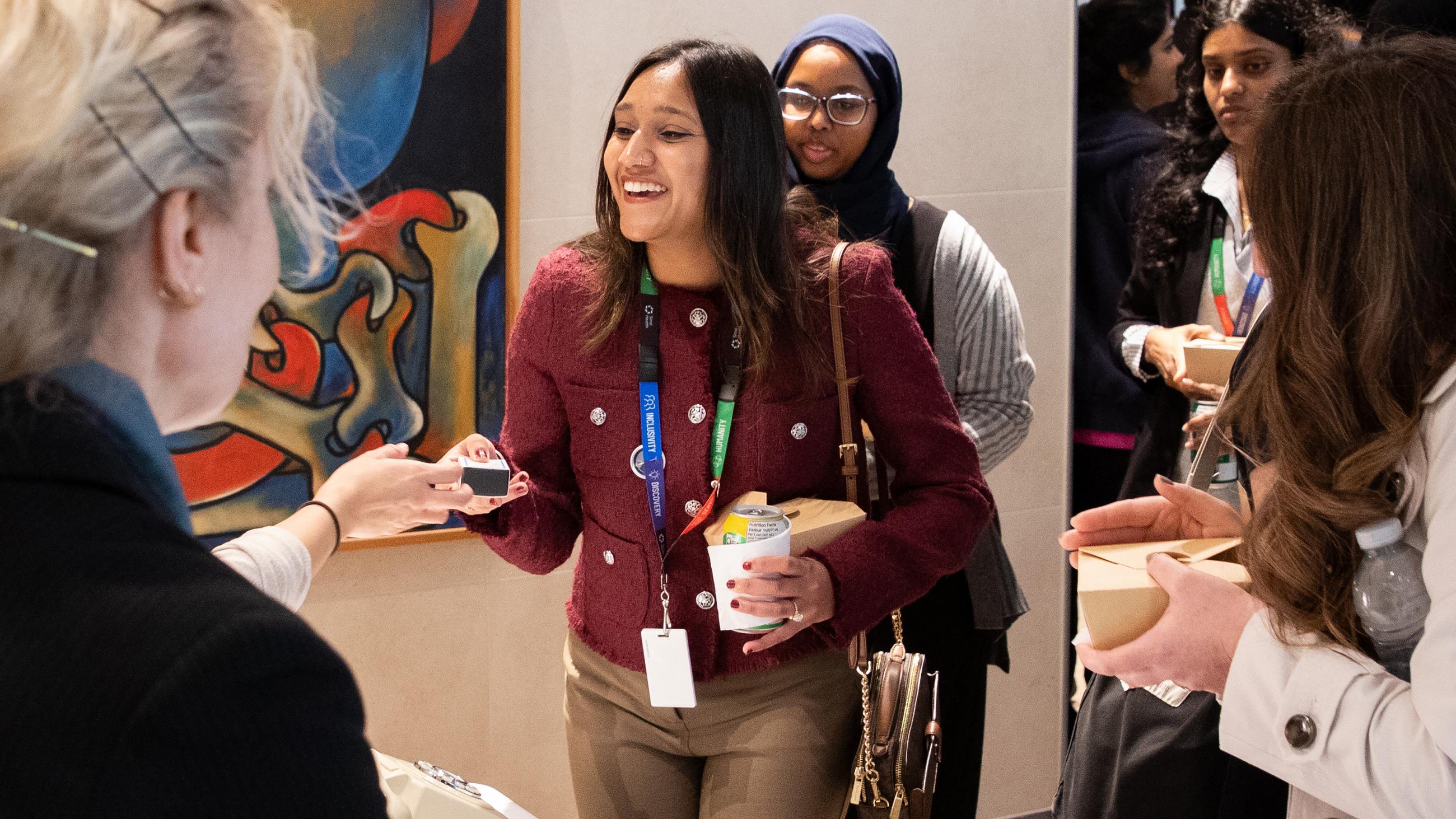 Service milestone recipient smiling as they receive a bon bon gift.