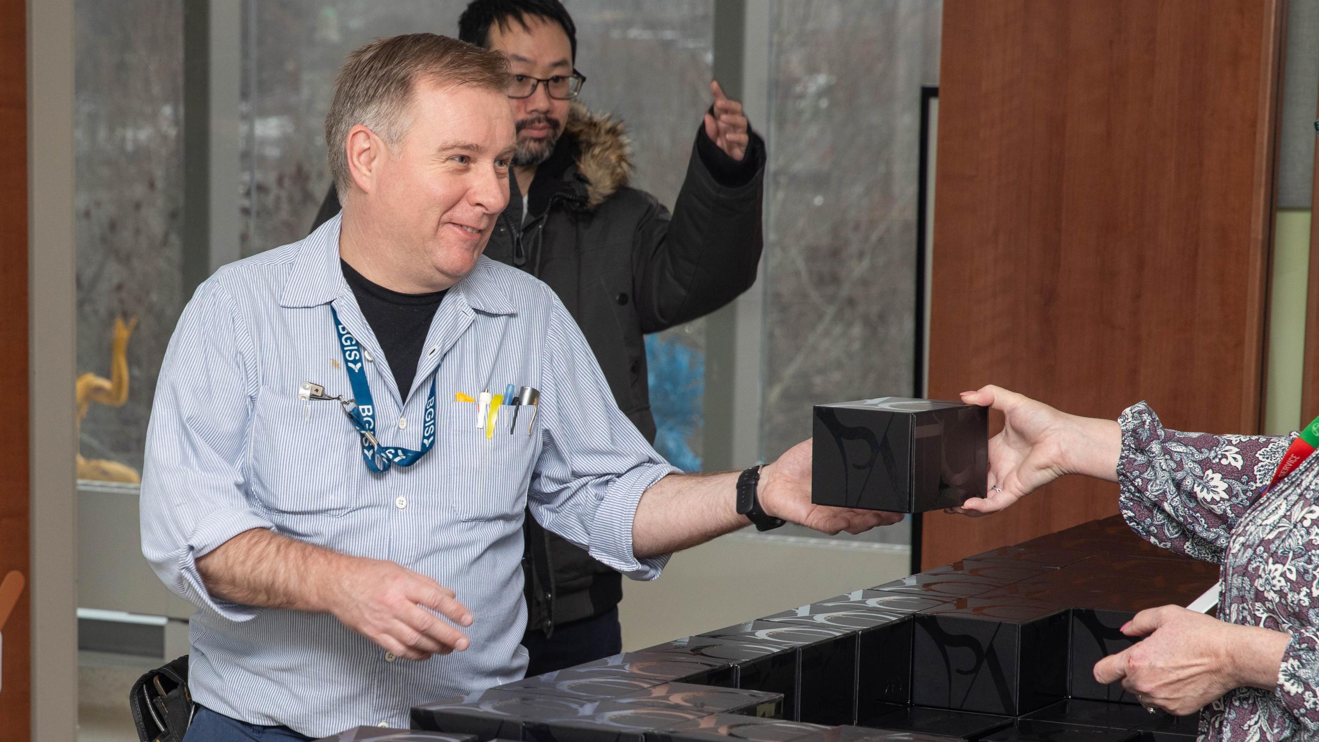 An attendee smiling as they receive a holiday treat at the open house. 