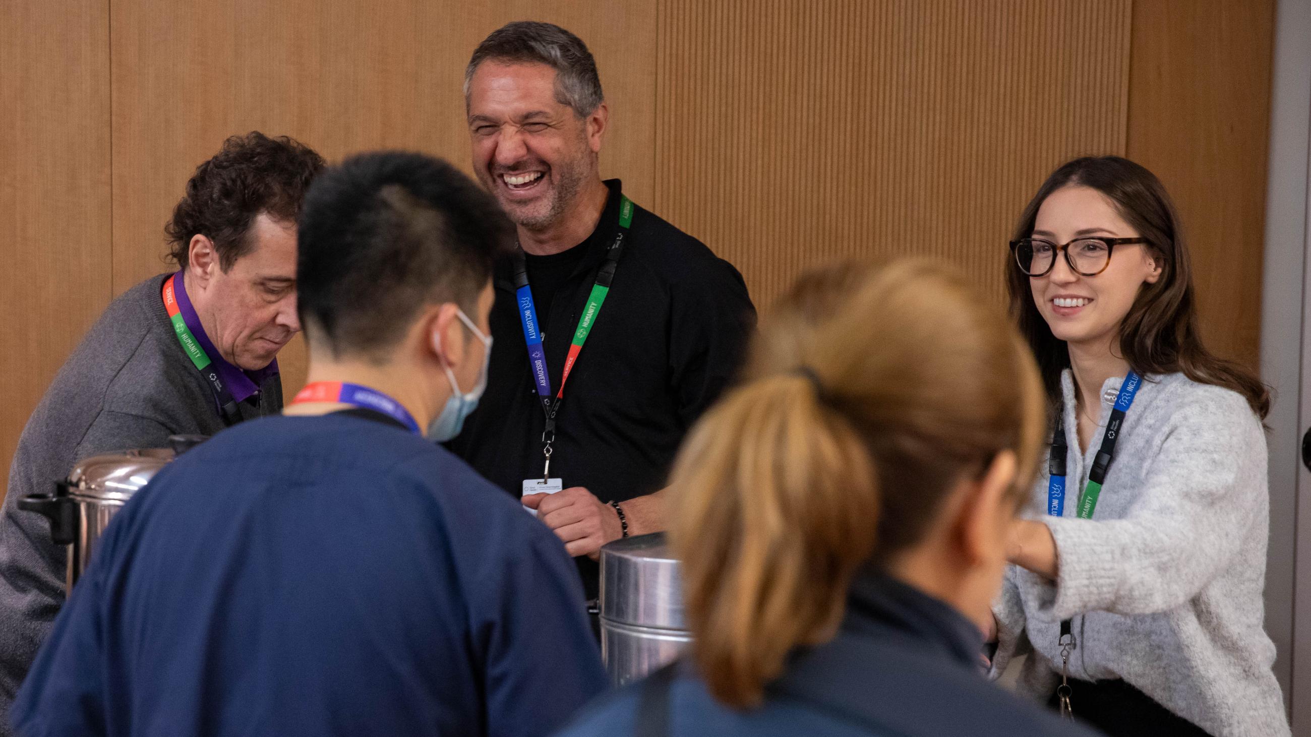 Team members handing out hot beverages to guests during the Holiday Open House.