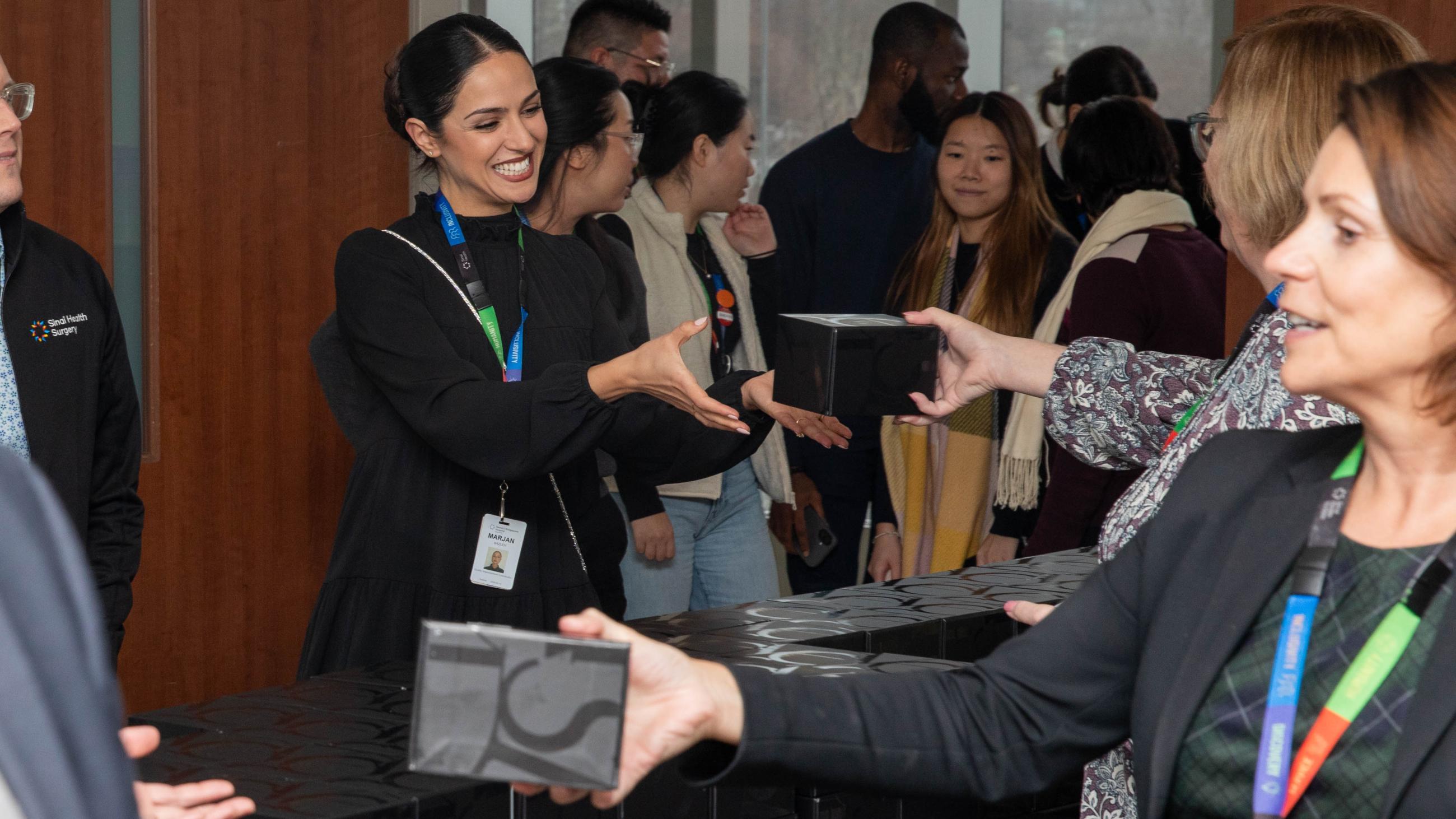 An attendee smiling as they receive a holiday treat at the open house. 