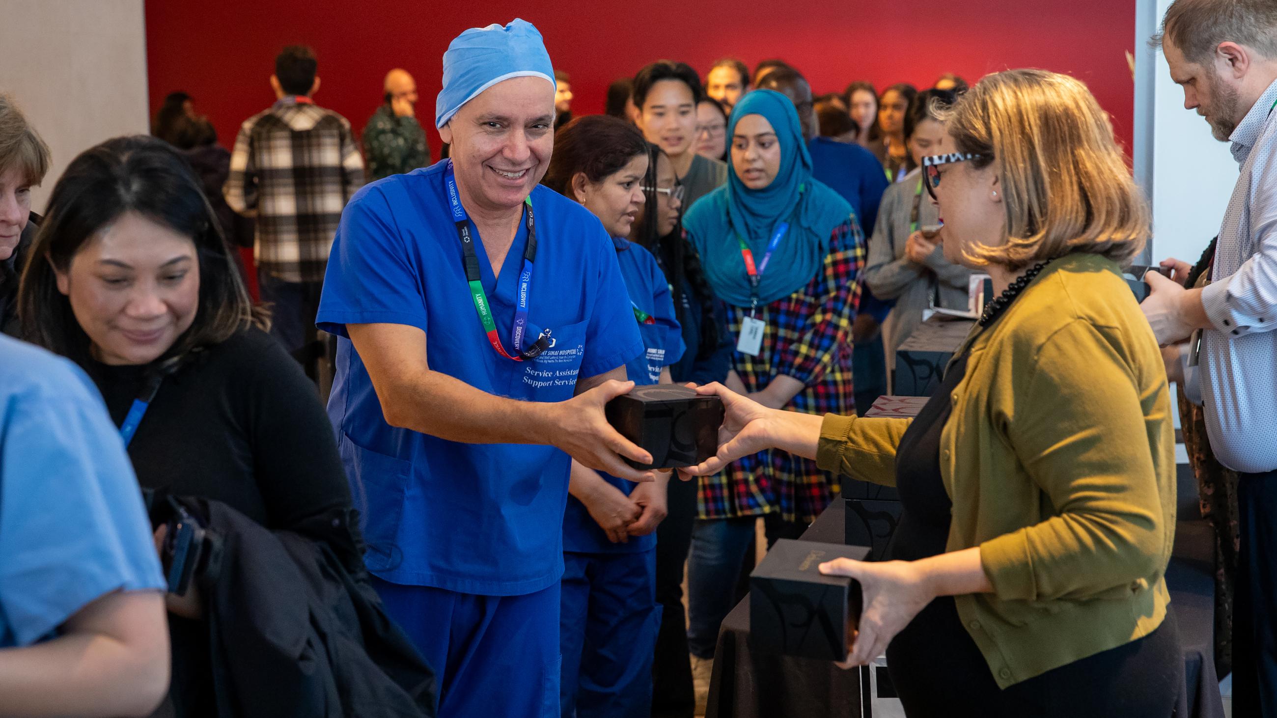 An attendee smiling as they receive a holiday treat at the open house. 