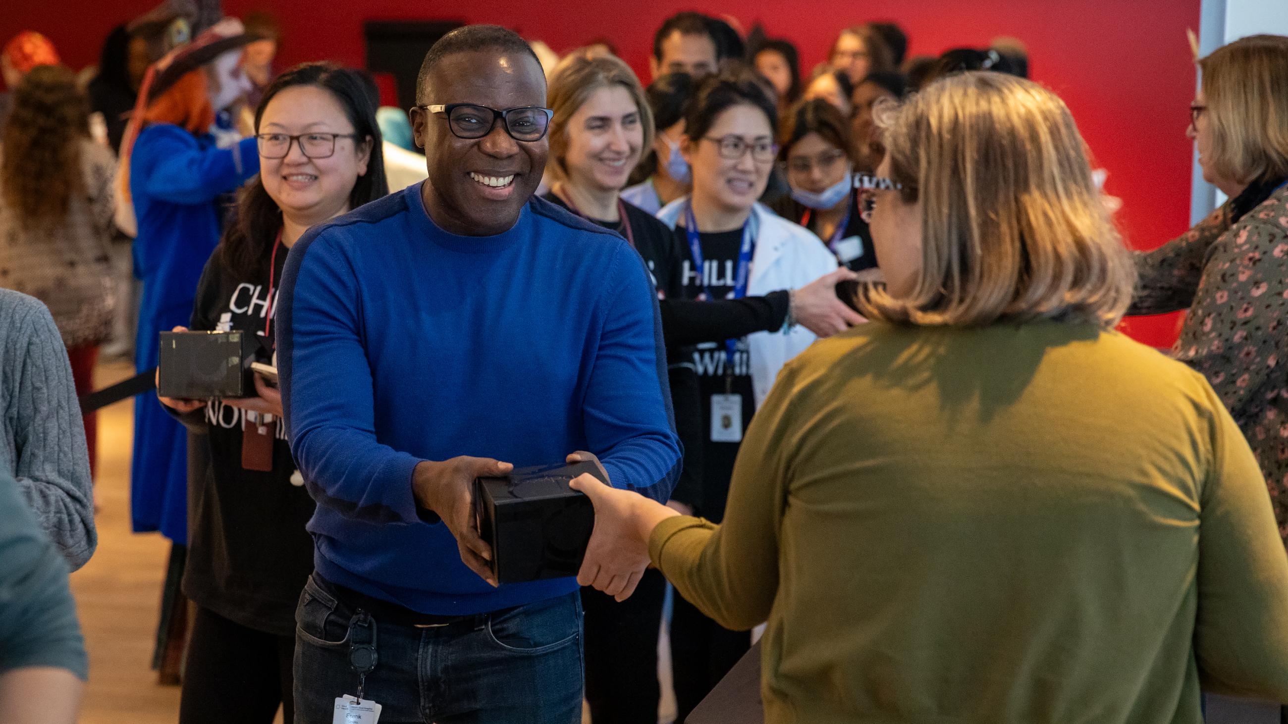 An attendee smiling as they receive a holiday treat at the open house. 