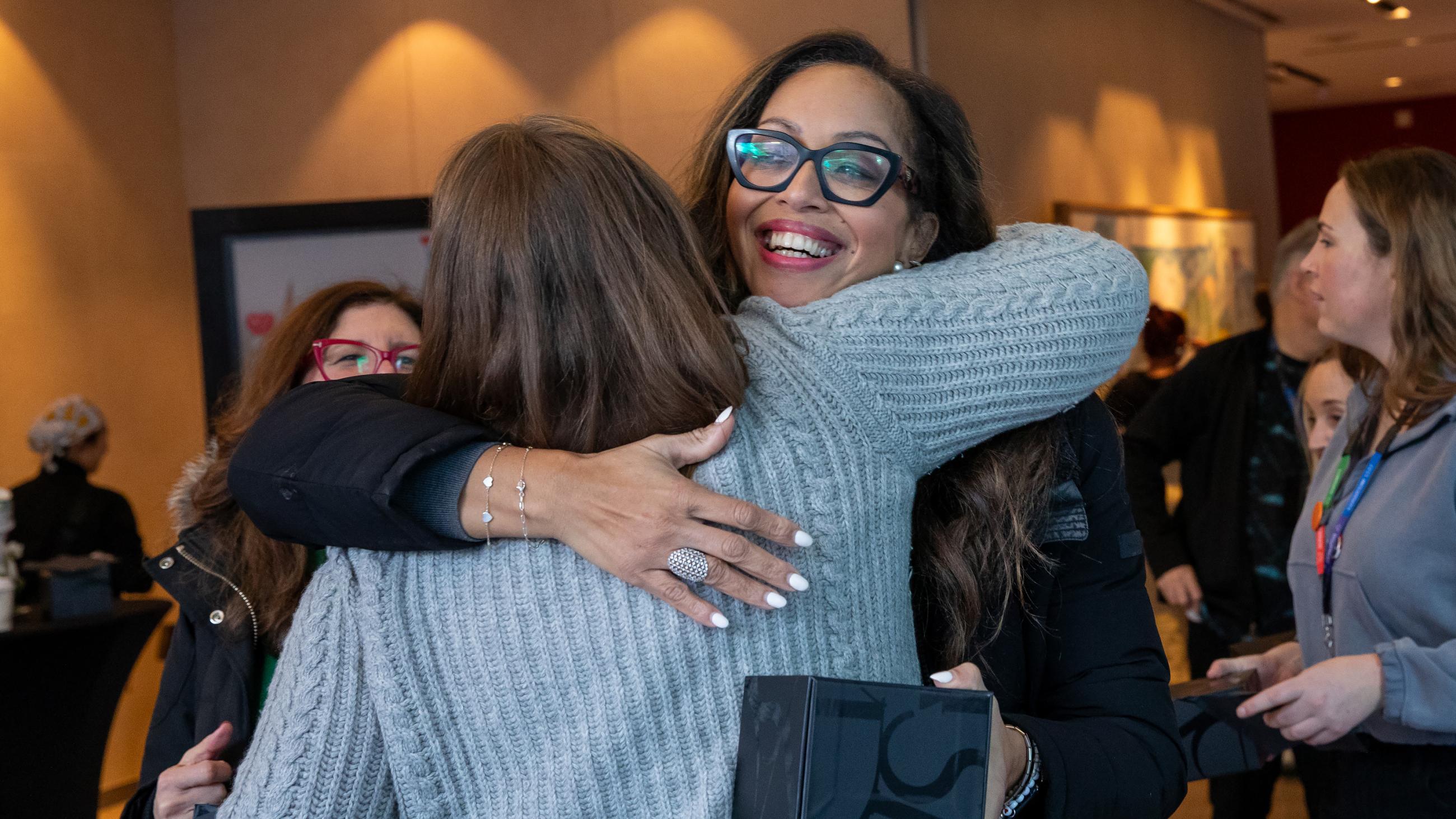 Two colleagues embracing each other during the open house. 
