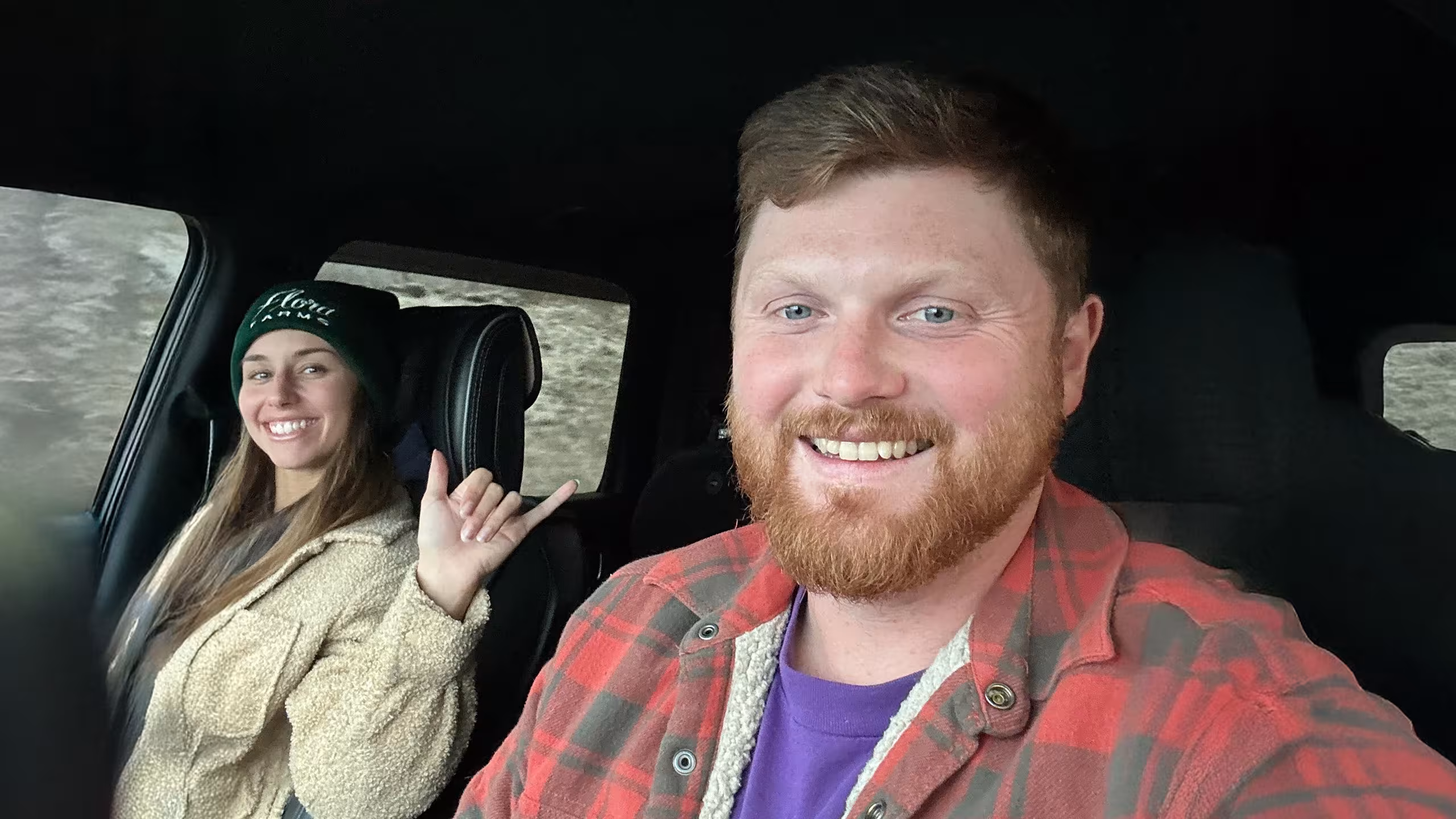 Man sits in drivers seat of car with wife sitting in passenger seat