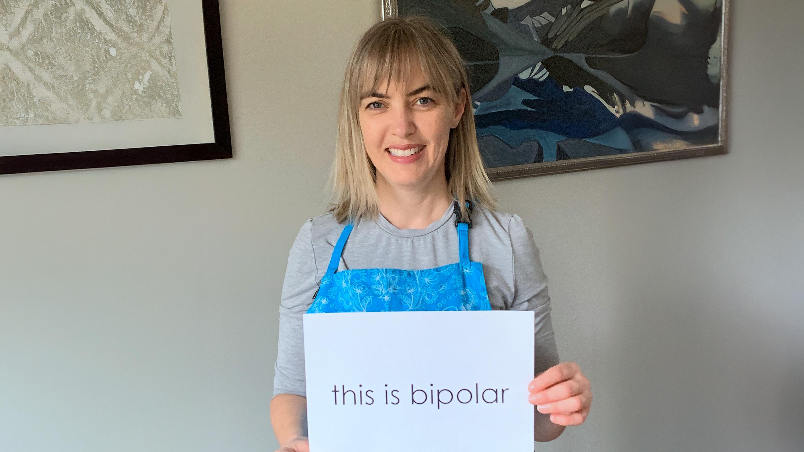 image of woman holding a sign that says 'this is bipolar'