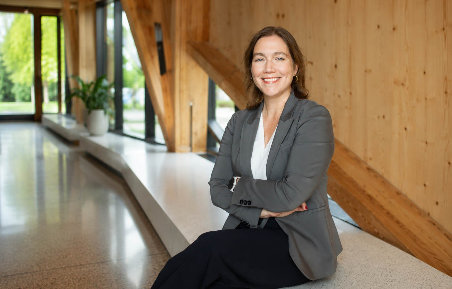 A woman sits on a bench with a smile on her face.