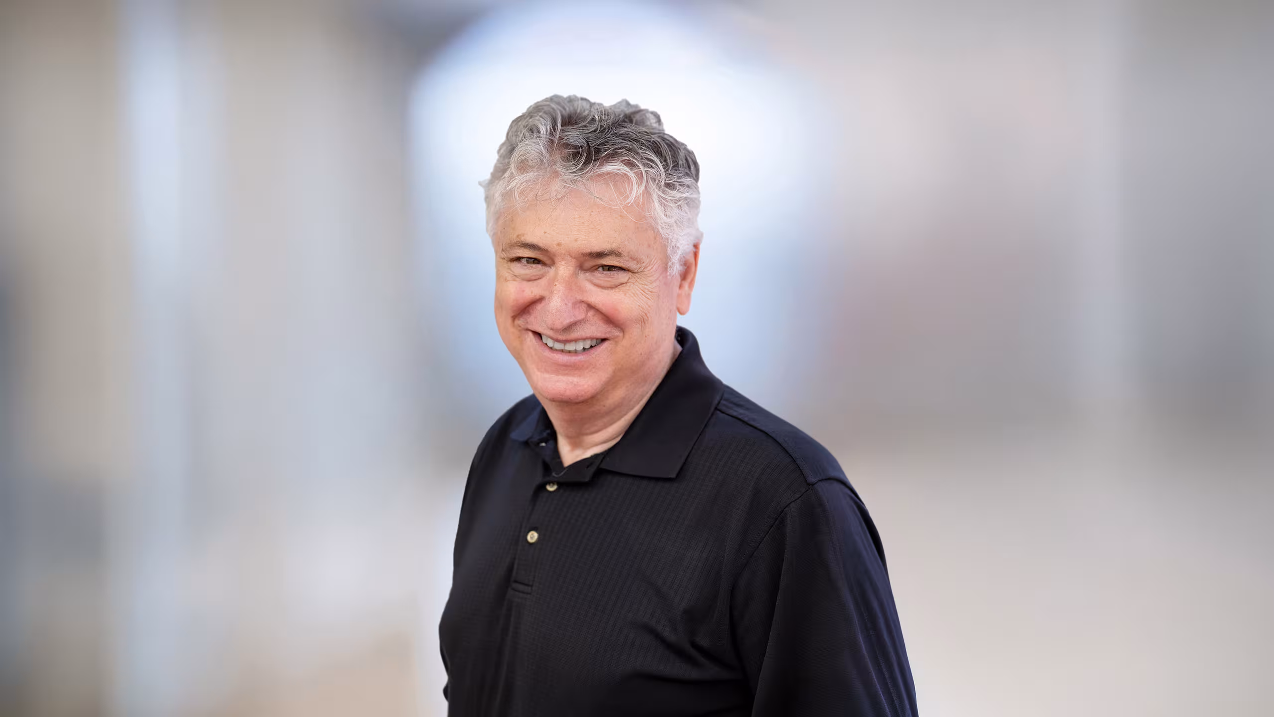 headshot of man wearing black shirt