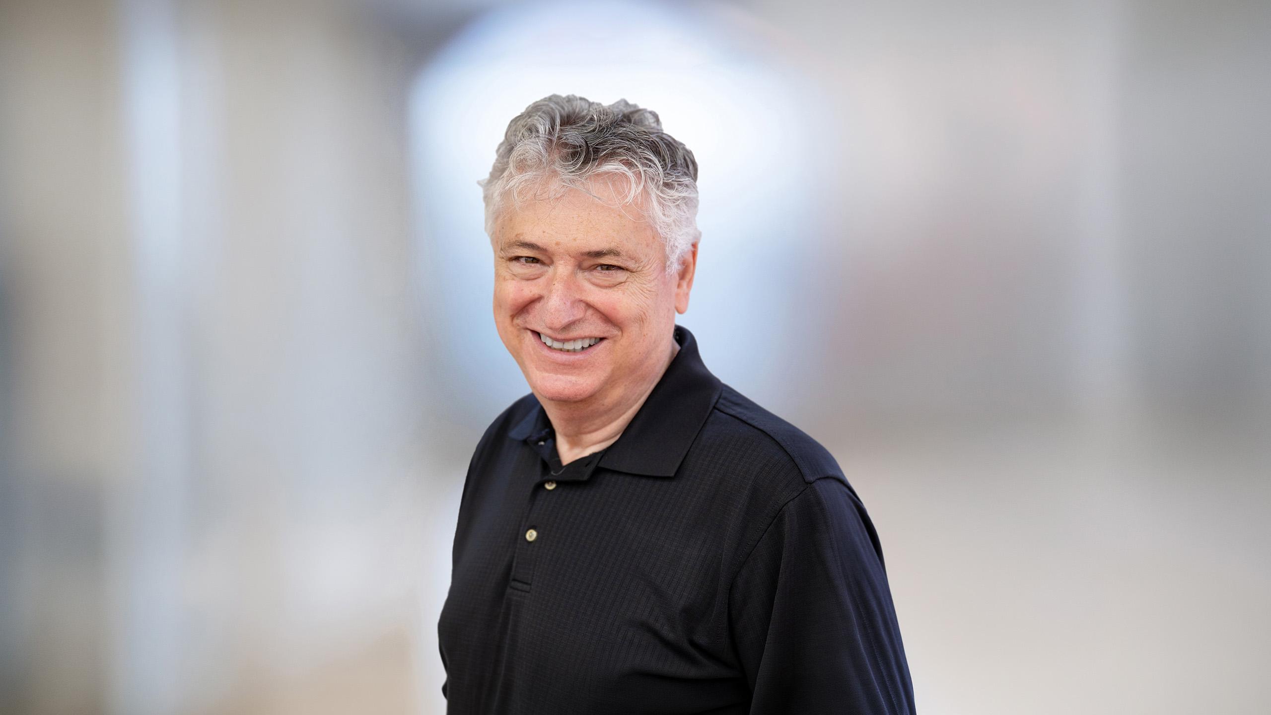 headshot of man wearing black shirt