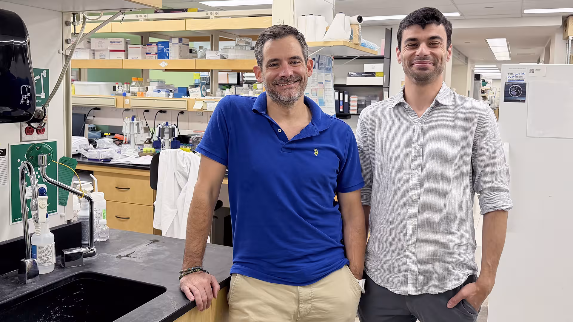 Drs. Daniel Schramek on the left and Khalid Al-Zahrani on the right standing in a scientific lab setting.
