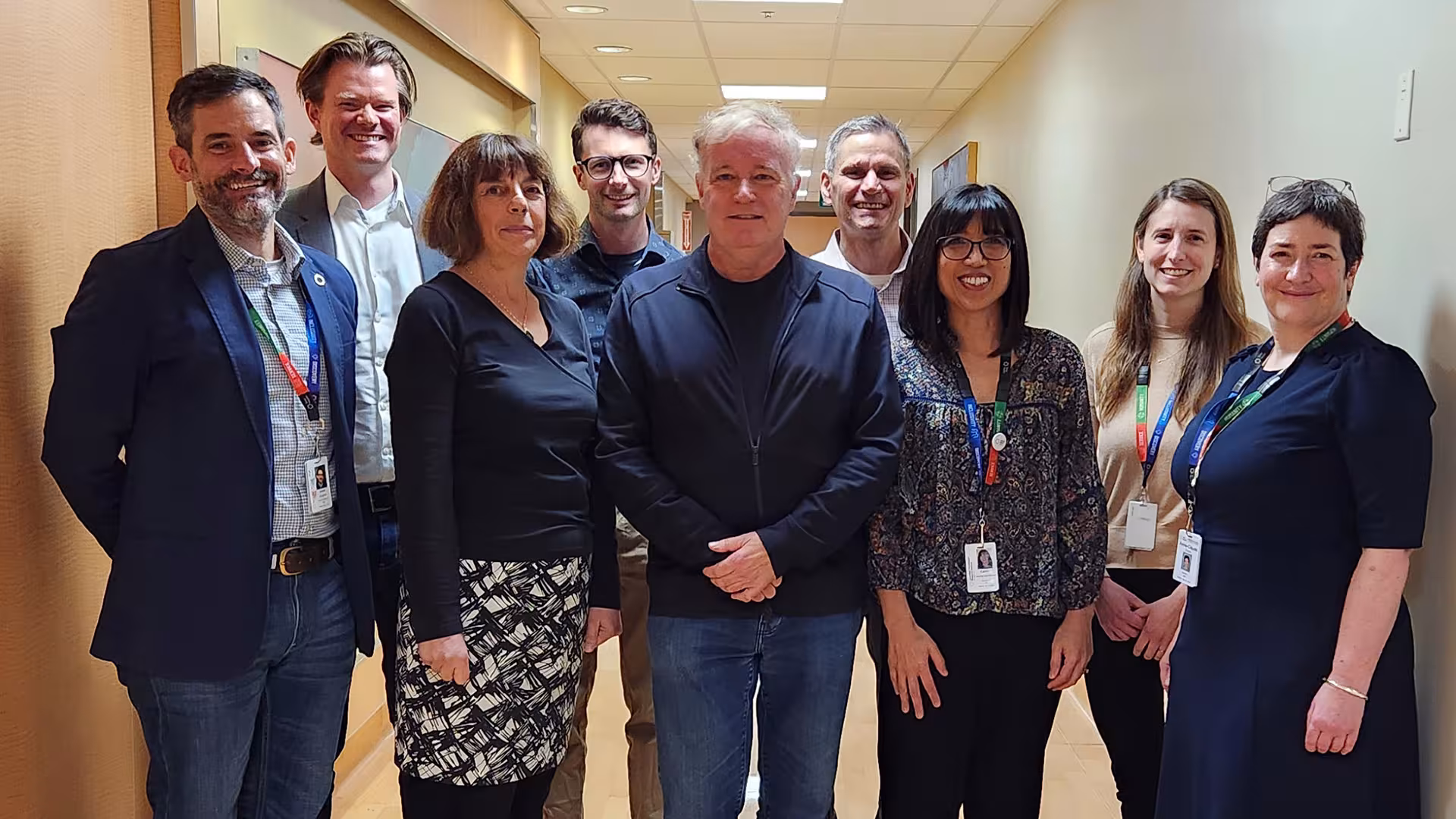 A team of researchers from Sinai Health and the University of Toronto standing in a hallway together smiling. 